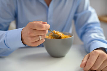 Elegancjo ubrany mężczyzna jedzący płatki śniadaniowe z mlekiem o poranku  © Paweł Kacperek