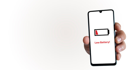 A hand holding a smartphone and a “Low Battery” warning on the phone screen. Device energy....