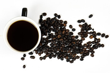 a black cup of coffee and coffee beans on a white background.