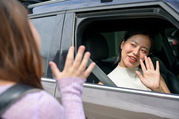 A caring and kind Asian mom is saying goodbye to her young daughter as she drops her off at school.