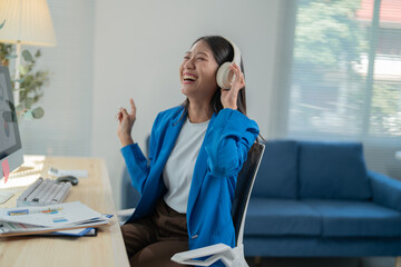 Businesswoman is enjoying music through headphones while taking a break from work, creating a positive and motivated atmosphere