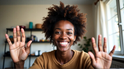 Happy black woman waving during video call at home