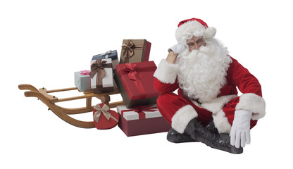 Santa Claus posing next to a small sleigh