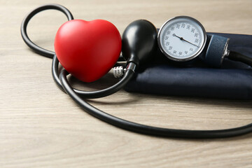 Blood pressure measuring device and squeeze heart on wooden table