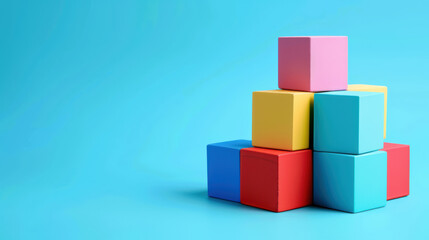 Obraz premium Colorful building blocks arranged in playful pyramid on bright blue background, creating cheerful and creative atmosphere