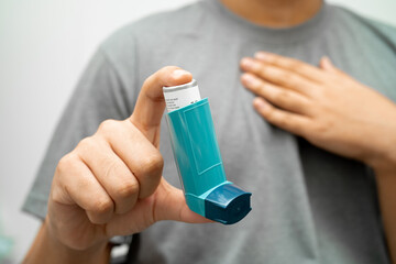 Asthma and chronic obstructive pulmonary disease COPD, Asian young man using metered dose inhaler...