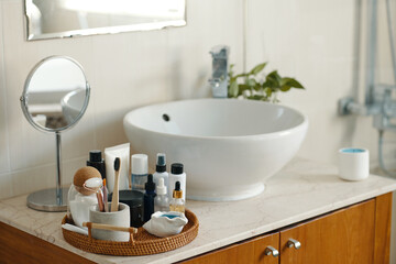 Modern bathroom vanity featuring clean lines and sleek countertop with various toiletries arranged...