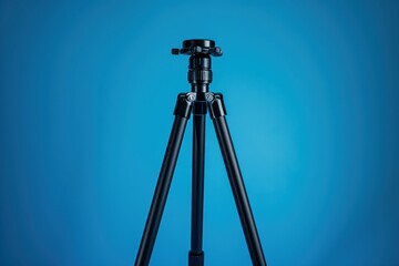 Black tripod with adjustable head set against a blue background