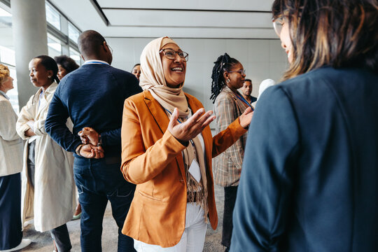 Smiling Muslim businesswoman sharing and talking during a networking event