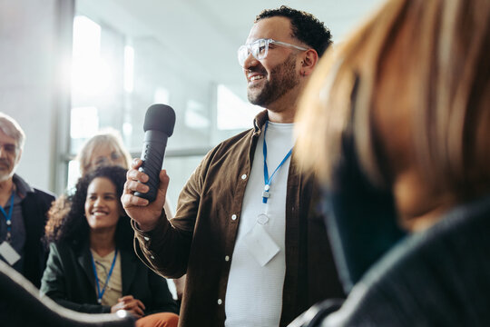 Enthusiastic participant engaging in questions and answers session at a seminar, fostering communication and achieving success