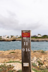 Wooden Signs on the coastal promenade Cami de Cavalls on the island of Menorca, which translated...