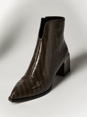 women's shoes with imitation crocodile skin on a light background