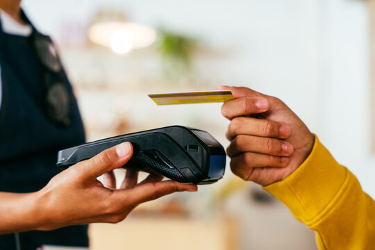 Card payment in a retail shop - Close-up on credit card and pos terminal to process the payment