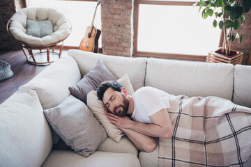 Photo of dreamy sleepy man lying on soft divan sleeping enjoying relax rest peaceful weekend...
