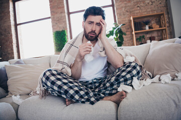 Photo of handsome tired young man wearing pajama staying home feeling unwell migraine blowing nose...