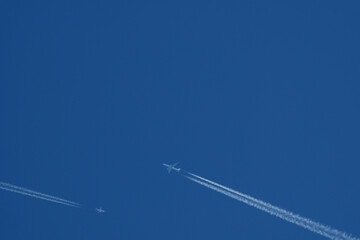 Two airplanes in the blue sky with contrail, contrails.