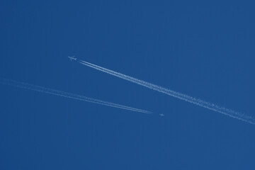 Two airplanes in the blue sky with contrail, contrails.