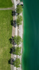 The Achensee view from top along a tree alley and the beautiful turquoise water as a beautiful nature contract composition