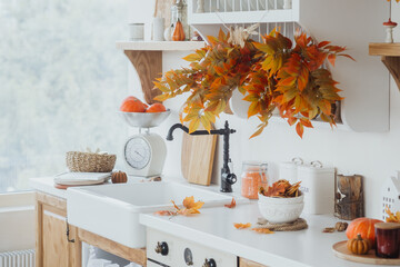 Cozy autumn kitchen with vibrant leaves and seasonal decor featuring pumpkins and warm colors