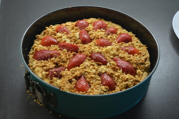Beautiful cooking, delicious homemade pies made with your own hands. A brown shortcrust pastry pie with a delicious, sweet filling and sliced strawberries.