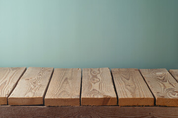 Empty wooden rustic table over green wall background.  Kitchen mock up for design and product...