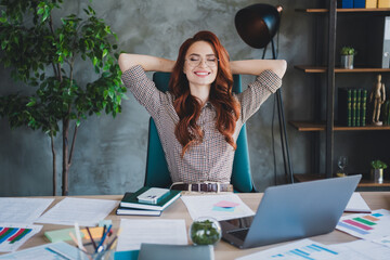 Photo of smiling positive lady boss formalwear having rest arms behind head indoors workplace...