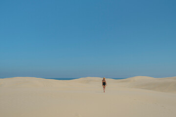 person walking on sand dune