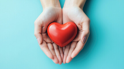Obraz premium Female hands holding red heart on blue background. Health care and medical concept. Symbol of love and support for cardiology, charity, disease help, and hope in medicine.