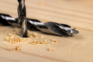 metal drill bit and pine wood board during operation