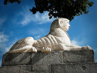 Majestic stone sphinx statue under blue sky.