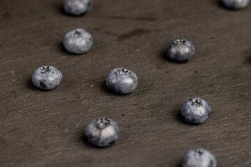 blueberries scattered on a black slate board