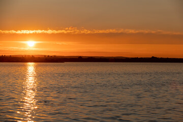 beautiful sunset with sun and orange sky on the lake