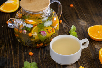 tea with orange and ripe sea buckthorn berries