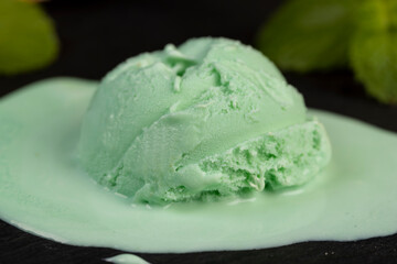 green ice cream with mint flavor on a black slate surface