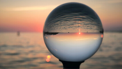 sunset by the Adriatic sea in Porec, seen through the glass lensball