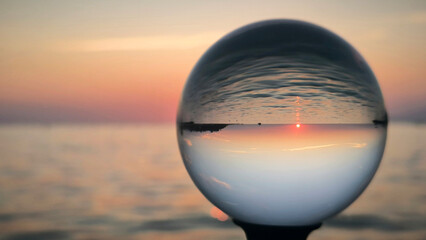 sunset by the Adriatic sea in Porec, seen through the glass lensball