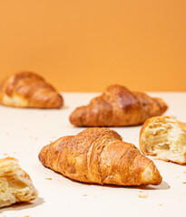Fresh croissants on yellow and orange background. Creative trendy layout and healthy food or french...
