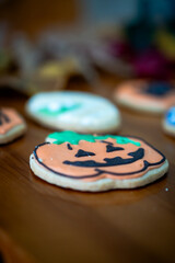 
Homemade Halloween-themed desserts. Various cakes containing the faces of different monsters of the Halloween holiday. Background containing autumn leaves.