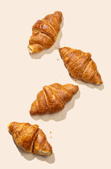 Flat lay of  fresh croissants on yellow  background with shadow.