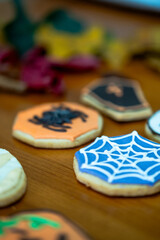 
Homemade Halloween-themed desserts. Various cakes containing the faces of different monsters of the Halloween holiday. Background containing autumn leaves.