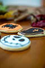 
Homemade Halloween-themed desserts. Various cakes containing the faces of different monsters of the Halloween holiday. Background containing autumn leaves.