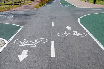 Obraz premium Bicycle lane markings on an asphalt road in a park in Astana, Kazakhstan, with green areas and paths for cyclists and pedestrians