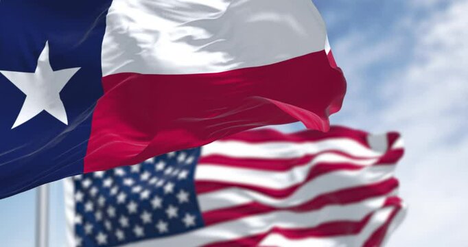 Texas state flags waving in the wind with american flag