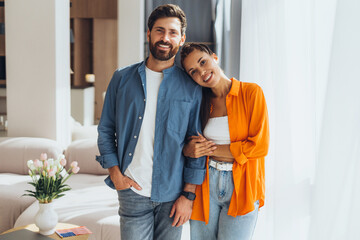 Portrait of positive happy Hispanic couple wearing colorful clothes looking at camera, fashion model
