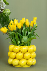 A vibrant arrangement of yellow tulips in a playful lemon-shaped vase perfect for brightening up any space in spring or summer