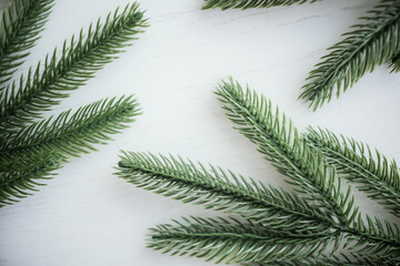 Obraz premium Evergreen branches arranged on a light wooden surface during daylight