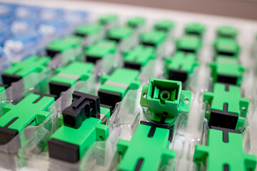 Optical adapters with different connectors in plastic blisters on the table, a batch of goods	
