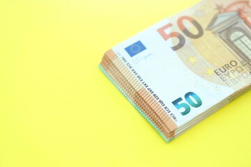 Big amount of one hundred and fifty euro money bills on yellow background