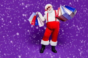 Full length body size view of his he nice cheery glad cheerful bearded thick fat Santa carrying...