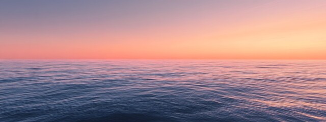 Fototapeta premium A calm sea at sunset, with the horizon blending into a gradient of purples and oranges, creates an atmosphere that feels serene and peaceful.